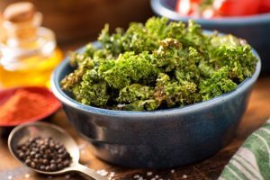 A bowl of crispy delicious baked kale chips. ** Note: Shallow depth of field
